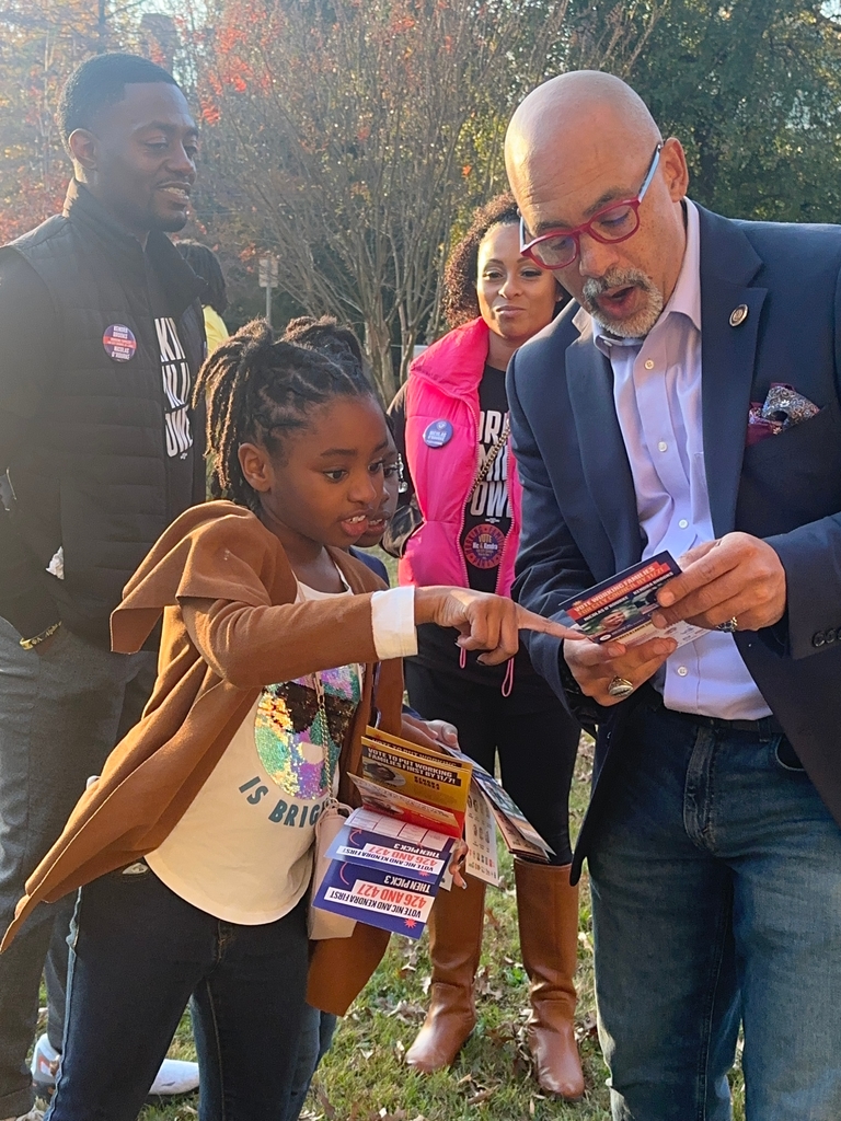 RepRabb and young voter with their parents look at campaign literature.  